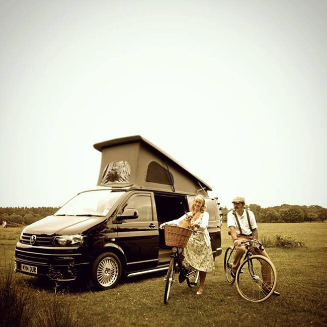 A coupe with their Pashley bicycles next to their VW campervan.