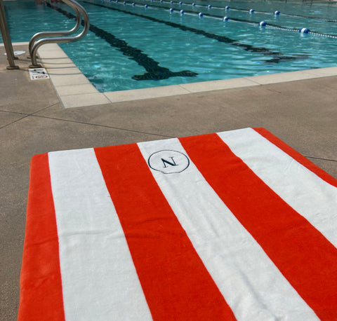 Striped pool towel in orange and white stripe pattern