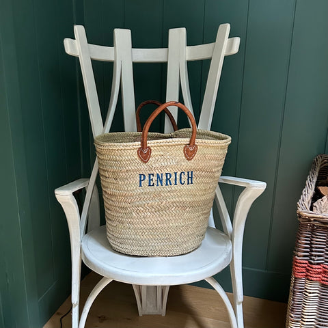 Large Covent Garden hand basket with embroidered monogram sitting on a white chair