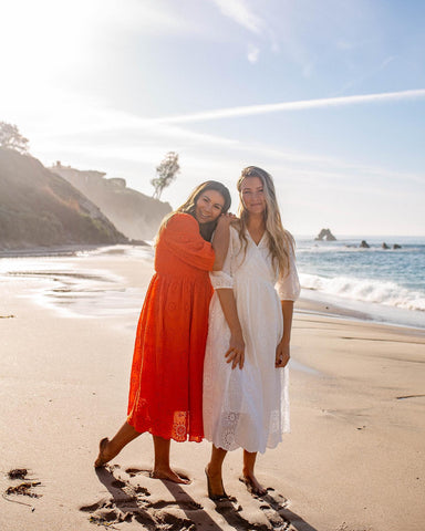 Two women wearing lace modest dresses on the beach