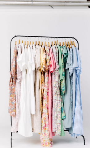 Colorful spring dresses hanging on a rack as a result of spring cleaning