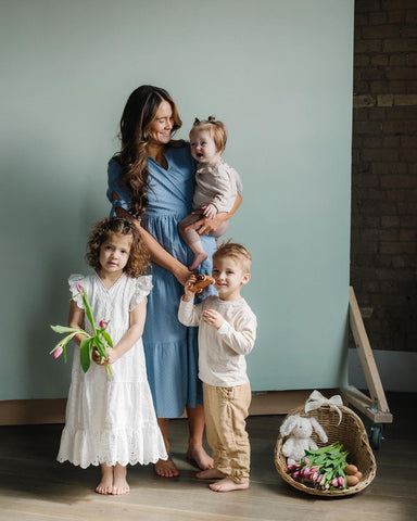 A mother posing with her three children in a studio set