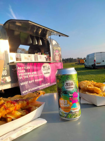 Can of Wild Un-bongo on a table with some gorgeous looking fish and chips in front of our Wildcraft branded mobile bar 