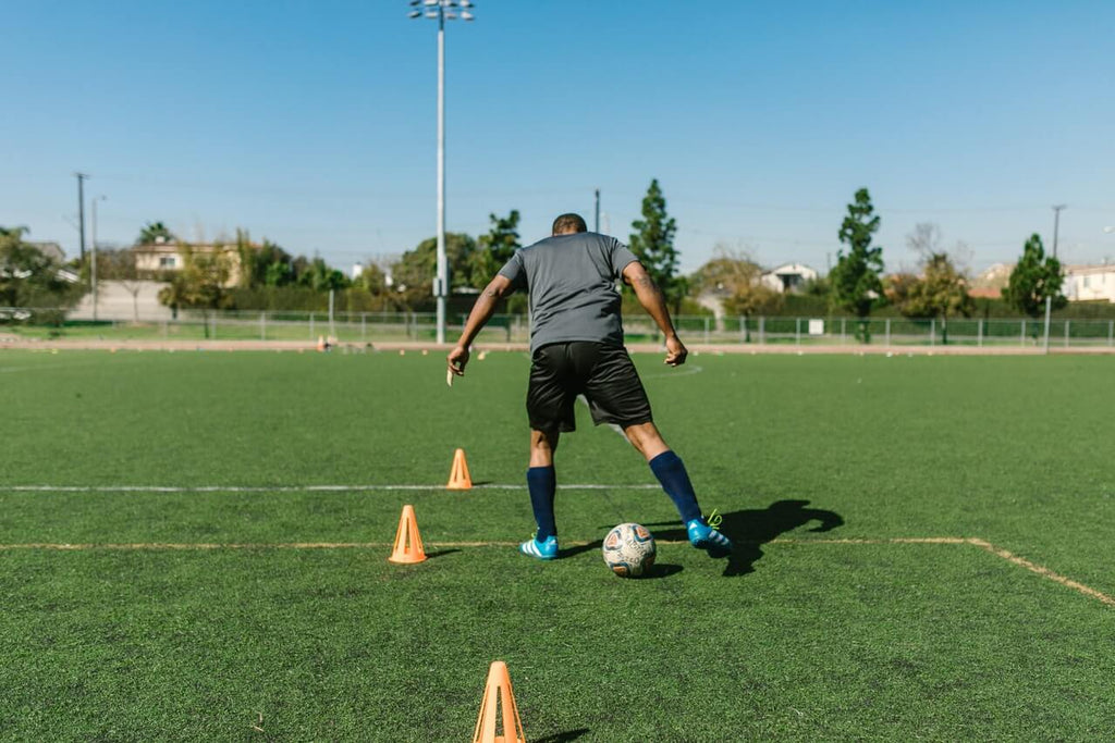 soccer player practicing with cones