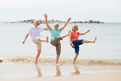 a group of children jumping on a beach