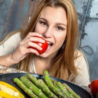 woman_eating_tomato_asparagus_pepper_corn_pic