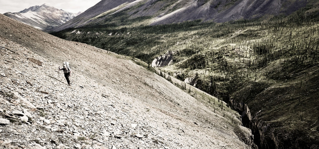 ultralight backpacker hiking up steep slope