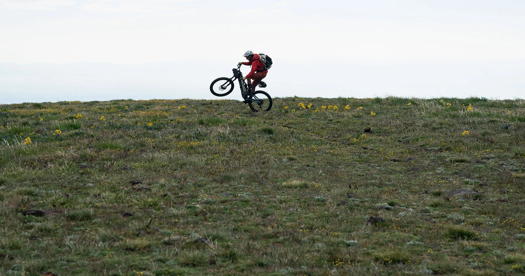 a bikepacker showing off with a wheelie