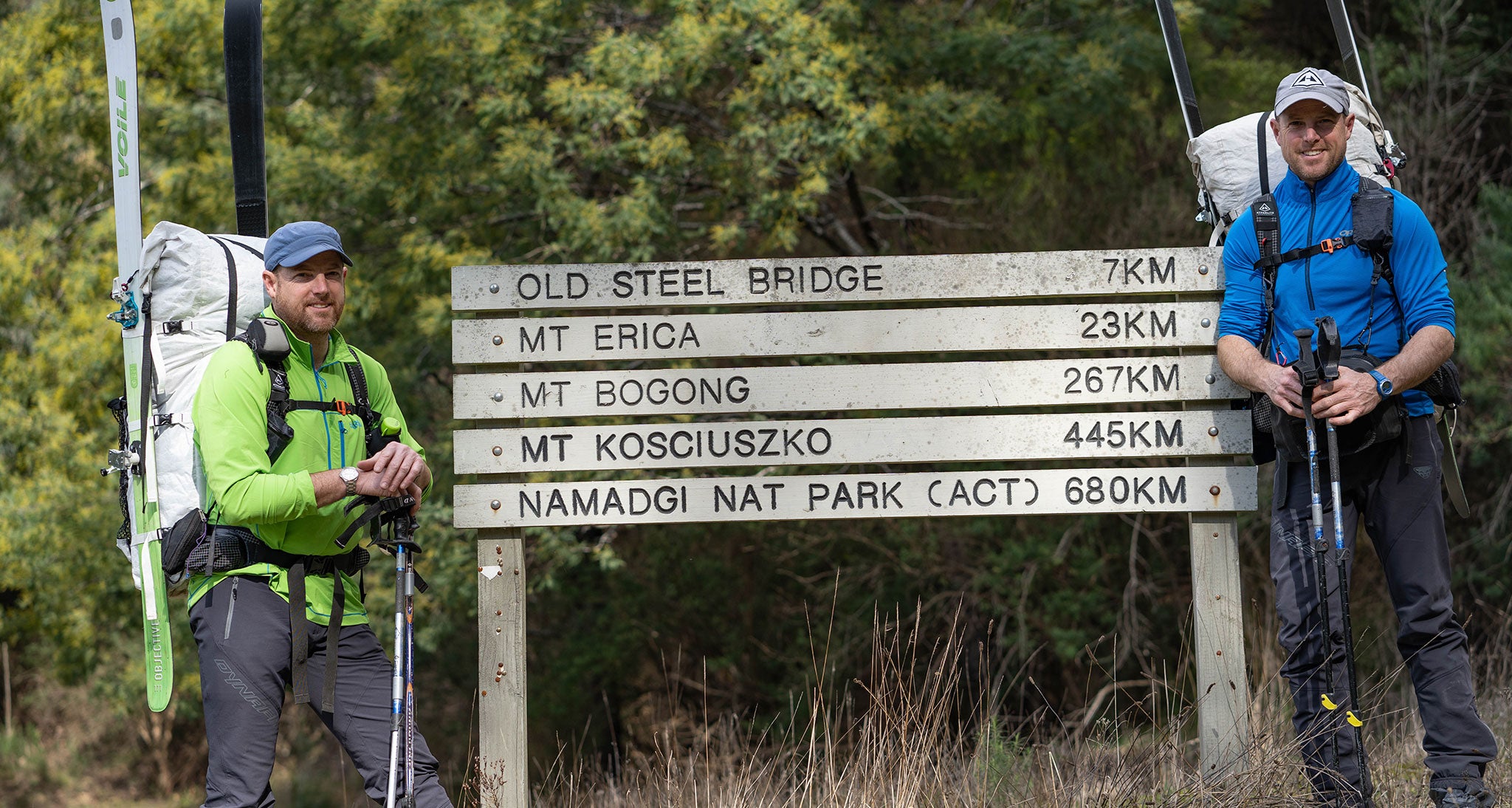 Ultralight backpackers posing near trail sign