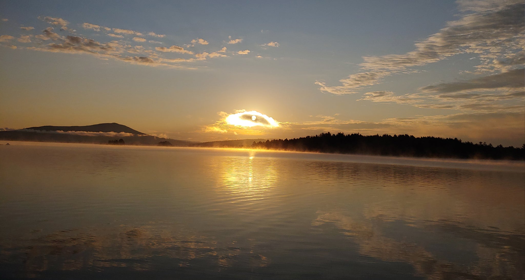 Sunet pokes through clouds over the lake