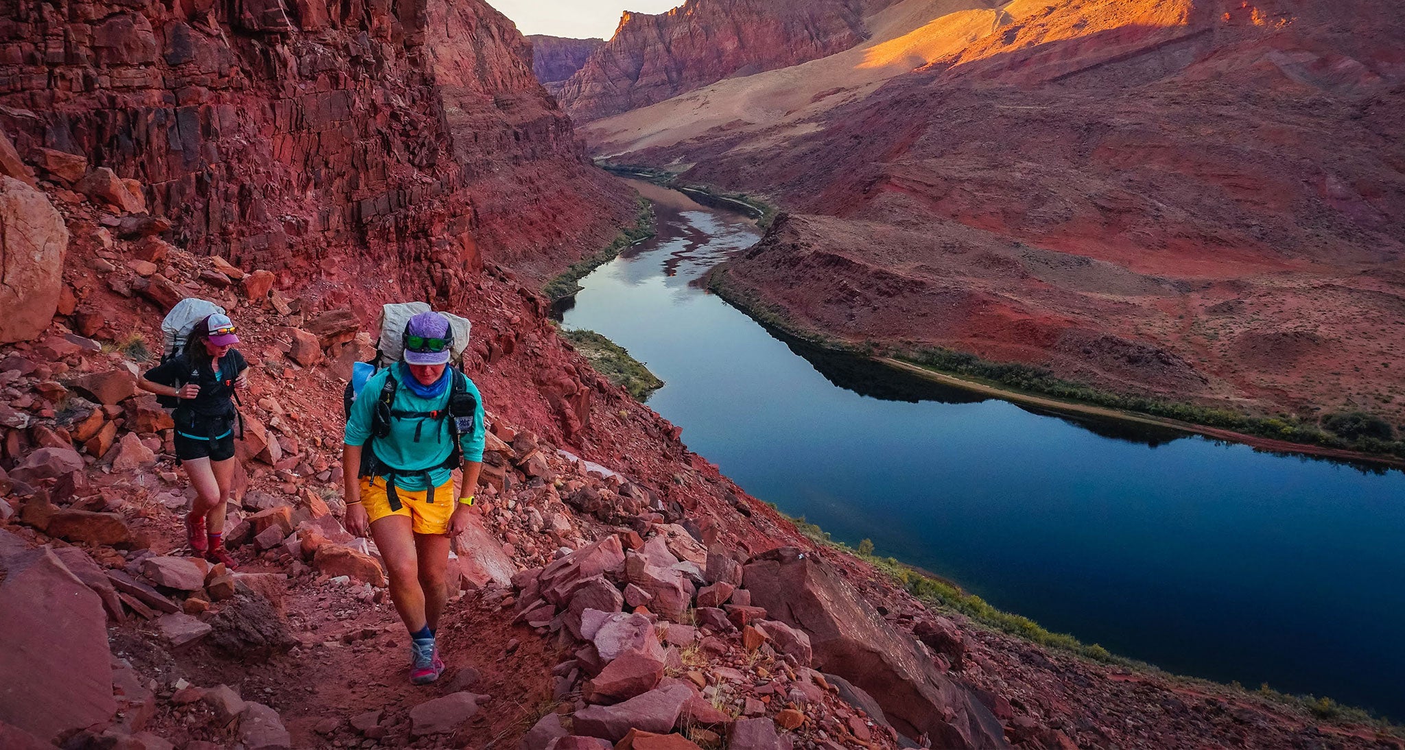 Hikers meander along a river in the desert