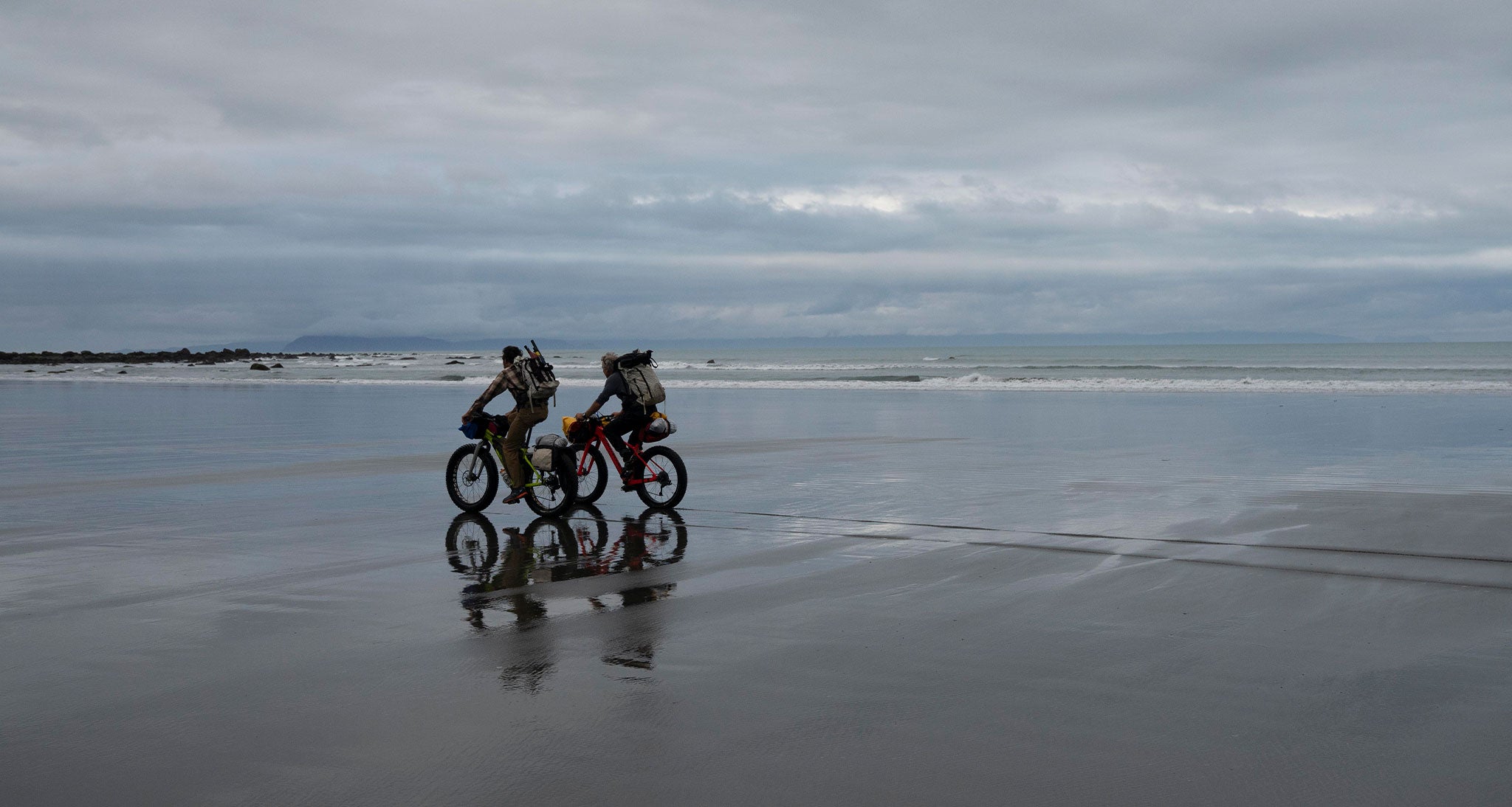 Ultralight bikepackers on the beach