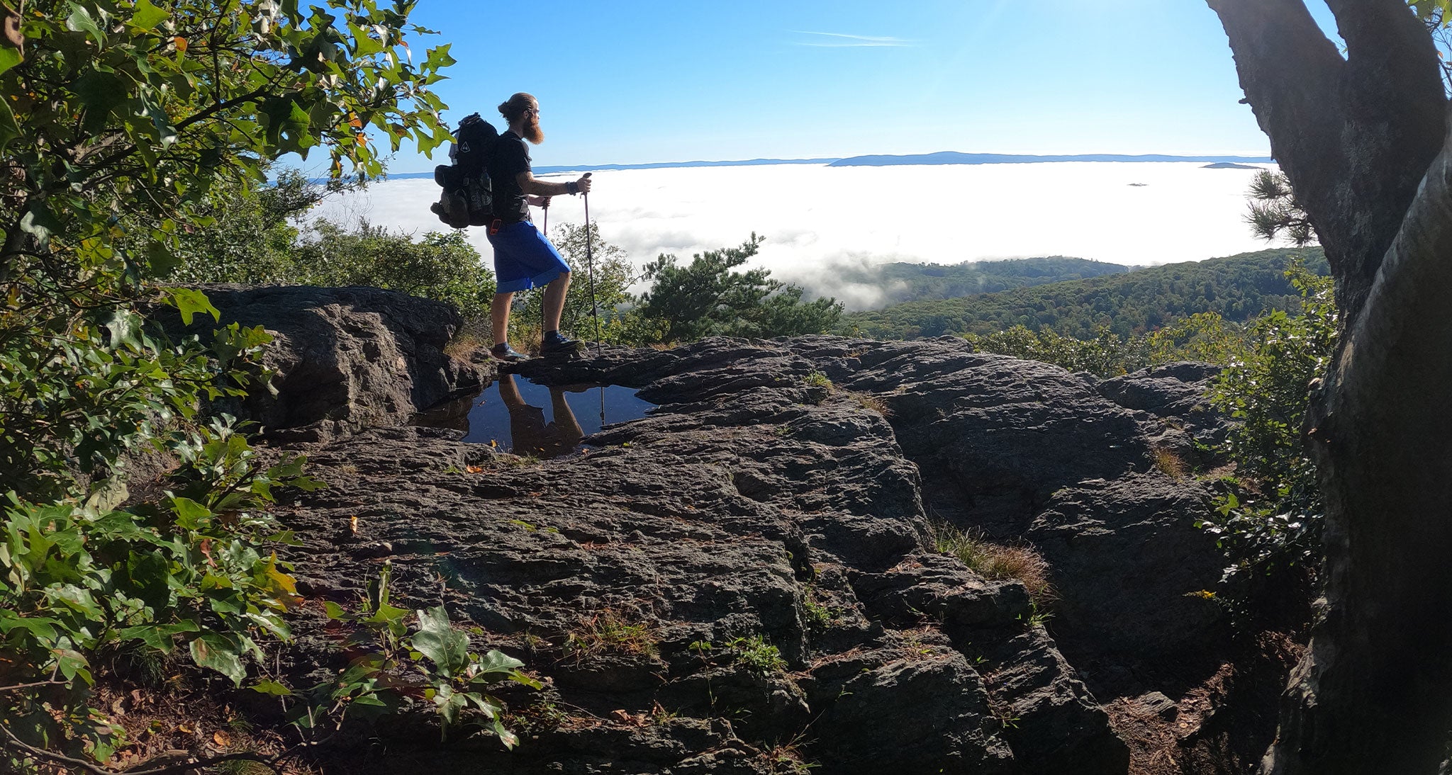 Hiker gazes forward above the clouds