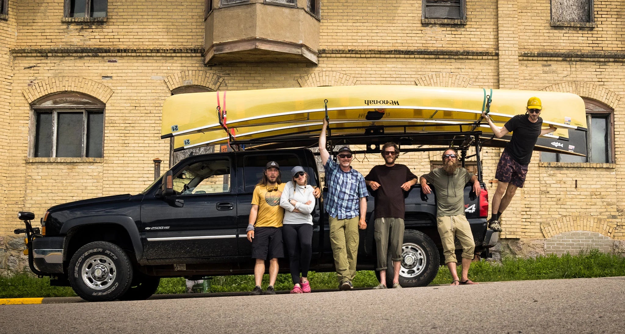 the crew in front of a truck with canoes installed