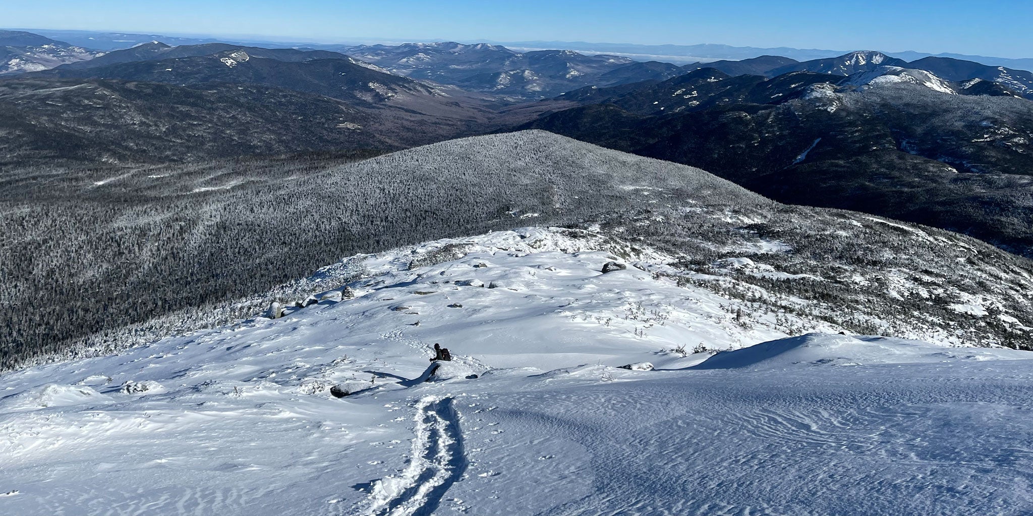 Hiker descends snowy mountain face