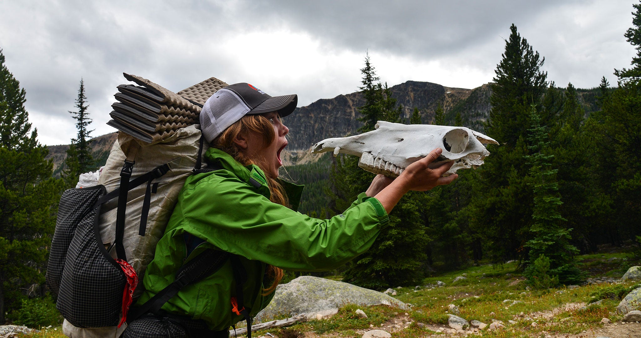 Ultralight thru hiker holding animal skull