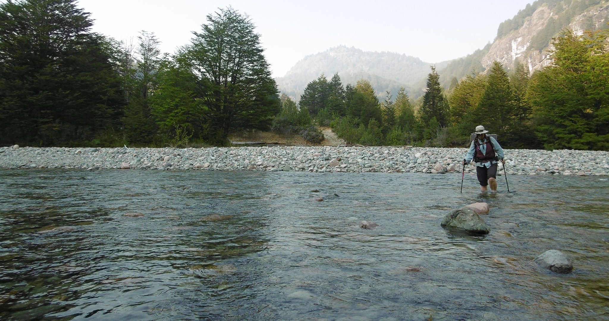 Ultralight backpacker crossing a river