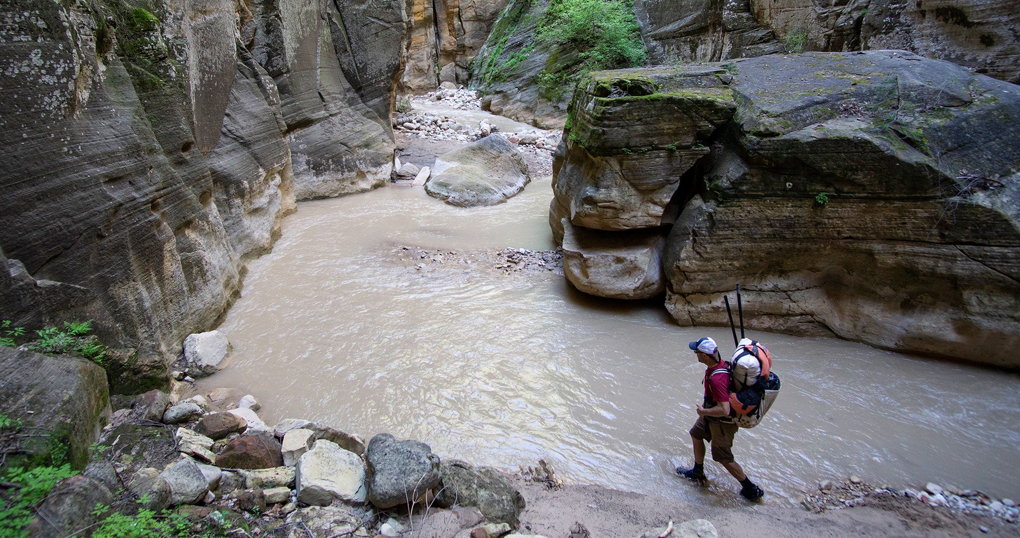 Ultralight Backpacker walking on the shore of a river