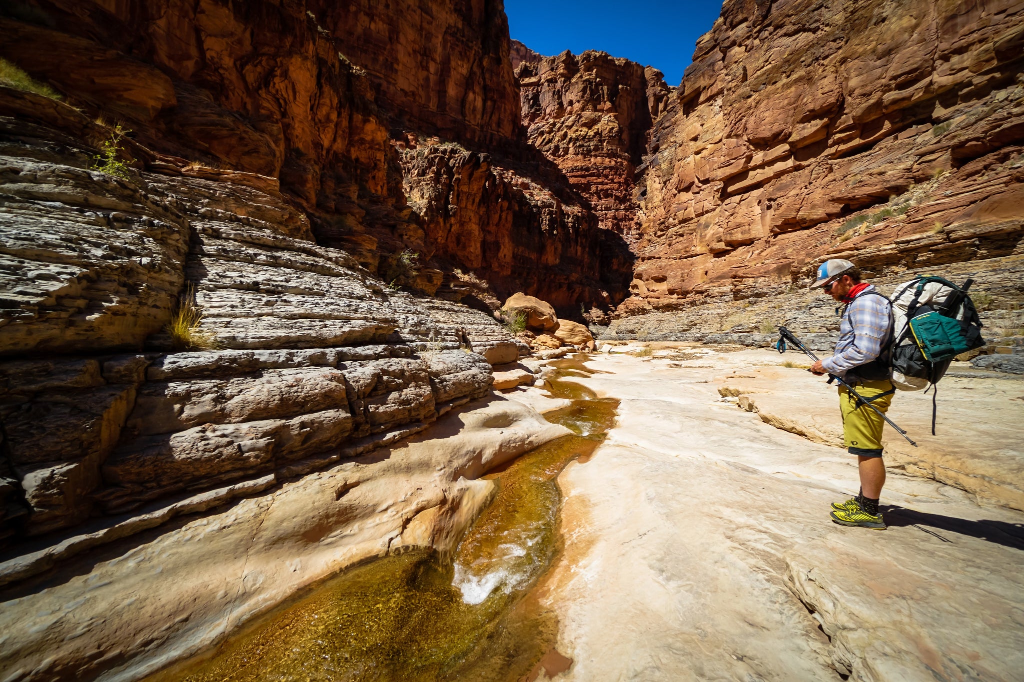 Hiker next to a small flowing stream in the desert canyons