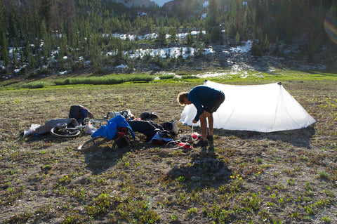 ultralight backpacker setting up tent