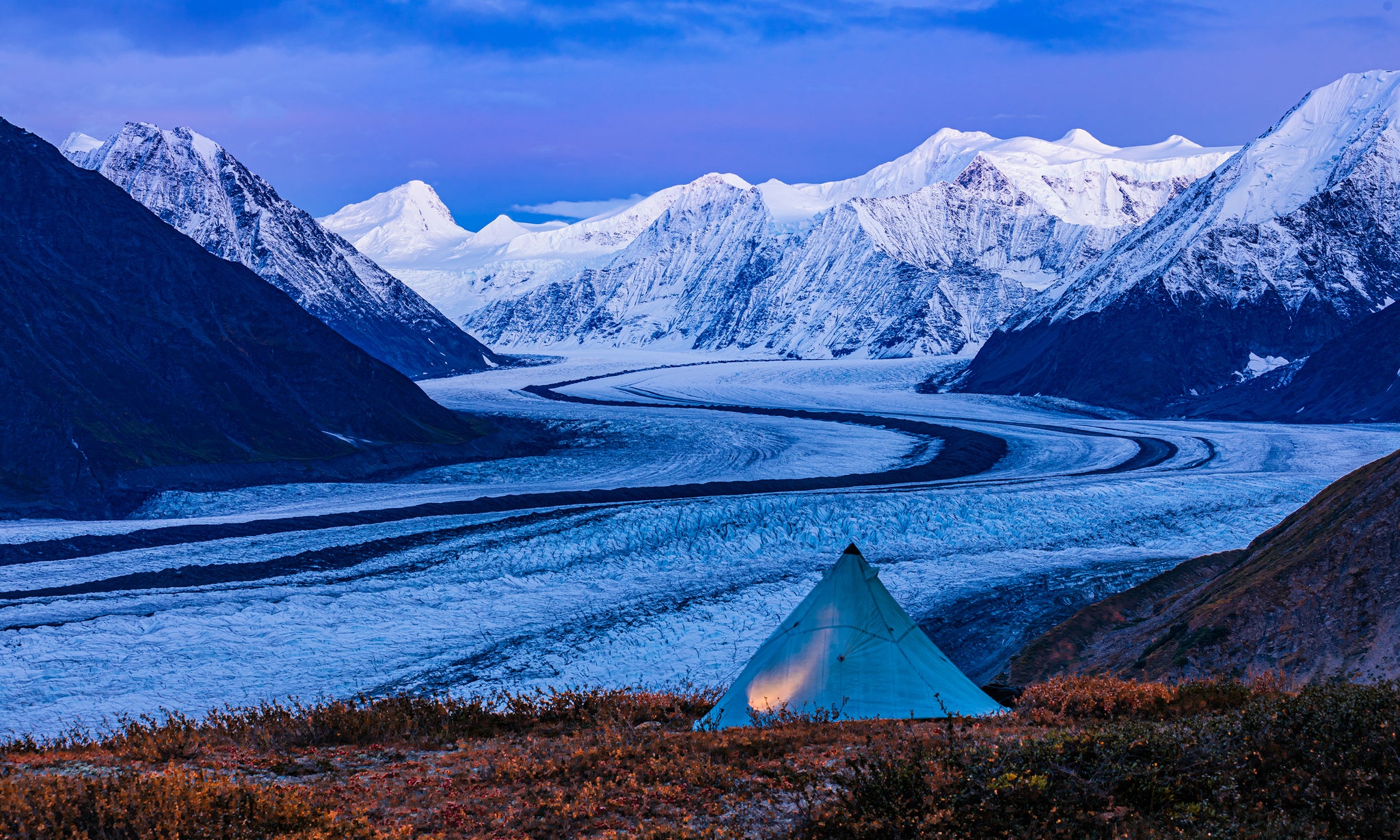 We like to camp high whenever possible. There is risk in exposure to nasty weather but this is where the best light for photography usually is. We have long since learned to make a secure camp in strong winds-always a risk around large glaciers such as this one, the Matanuska Glacier in Alaska’s Chugach.  