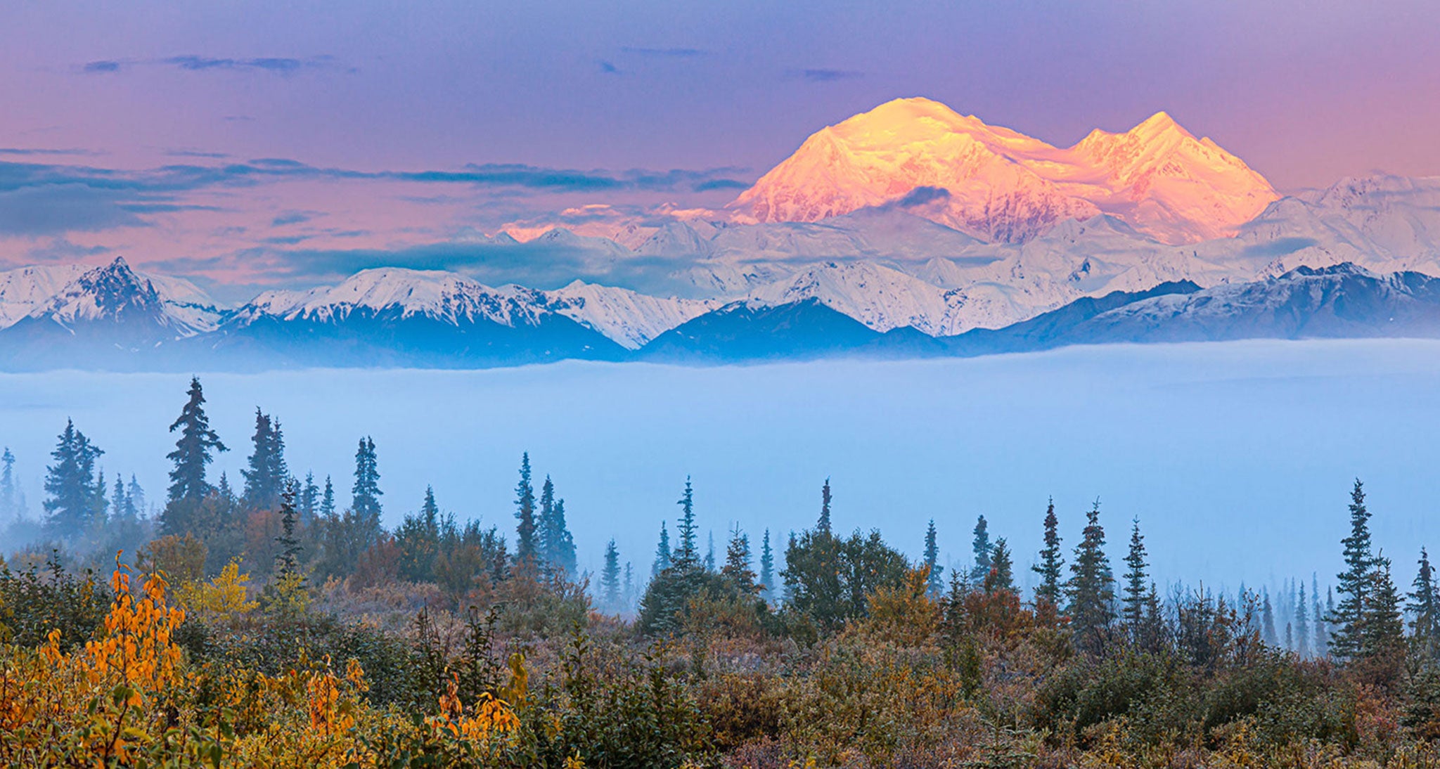 Sunrise on the eastern face of Denali and the Alaska Range reveals itself after a typical prolonged period of clouds and rain.  The only significant cloud left in the wake of this wet system is fog and stratus trapped on the valley floor under a temperature inversion.  Alaska has an abundance of low level moisture from lakes, rivers, wetlands and the ocean.
