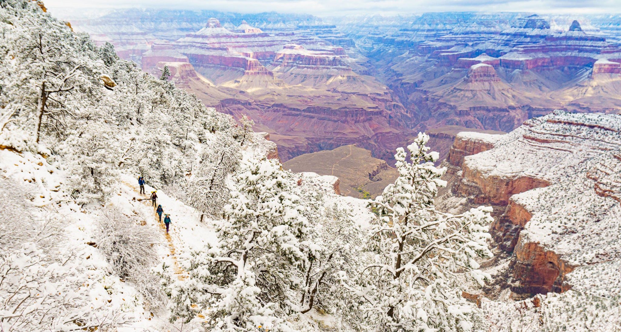 Four backpackers descend Bright Angel Trail in Grand Canyon National Park just below the rim.  An early winter Pacific cold front brought 5-6
