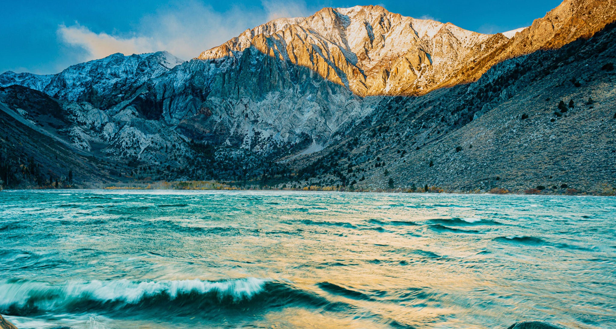 A stiff west wind at sunrise blows across Convict Lake in the Eastern Sierra, CA.  This is a downslopping wind.  Strong winds blowing across a mountain range flow downward on the lee side of the range as seen here.  Downsloping winds are drying winds and the western slope of the Sierra which would be on the windward side is probably  experiencing considerable cloud cover and precipitation.  Winds accelerate when they descend and accelerate even more when they blow across a surface with reduced friction such as a lake.  The high Sierra is the most prominent and formidable terrain barrier in the CONUS.  They are the reason why the Owen's Valley in their eastern shadow is a desert.