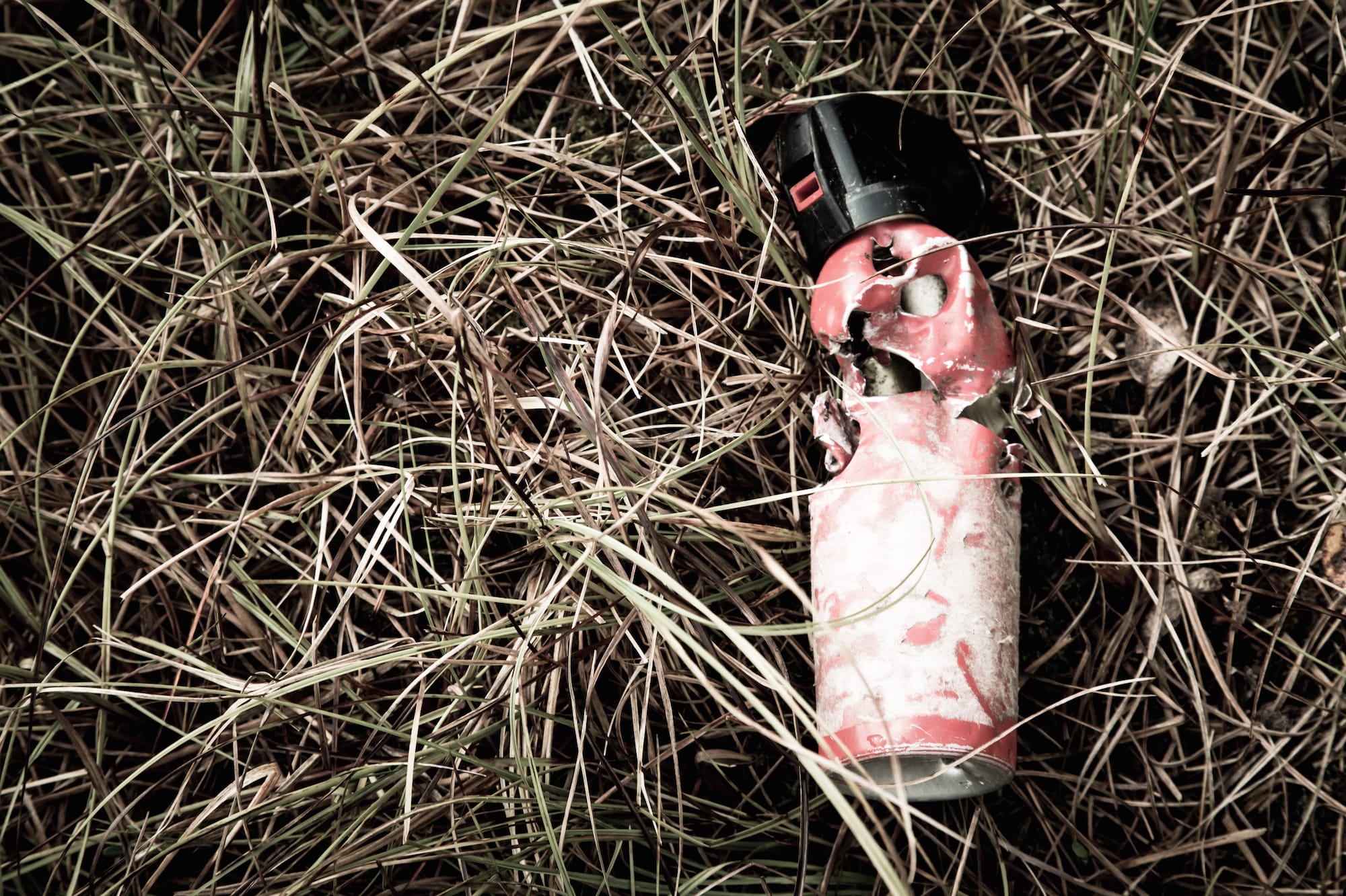 Damaged can of bear spray in the grass