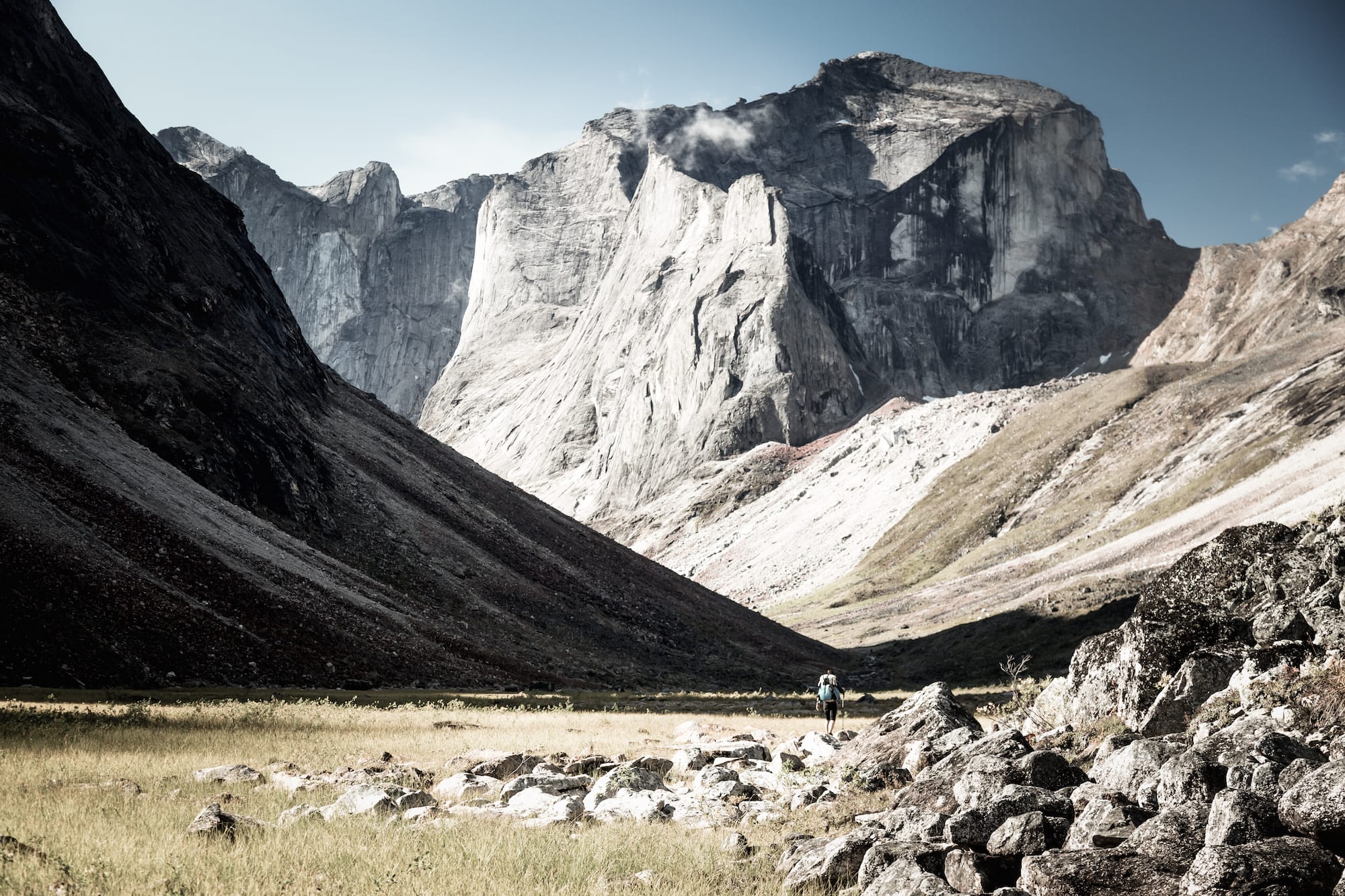 Ultralight backpacker traversing valley between mountains