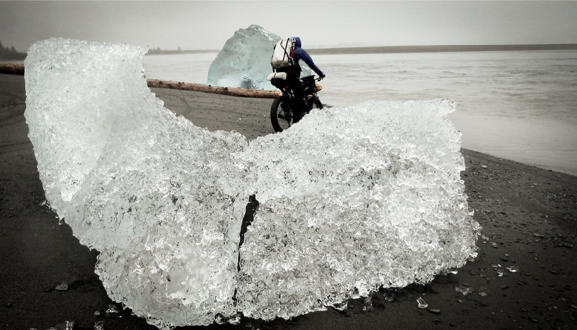 Large Chunk of ice on a beach with Ultralight Bikepackers