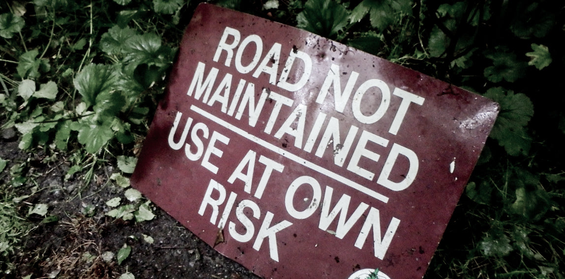 Sign that reads: Road Not Maintained Use At Own Risk