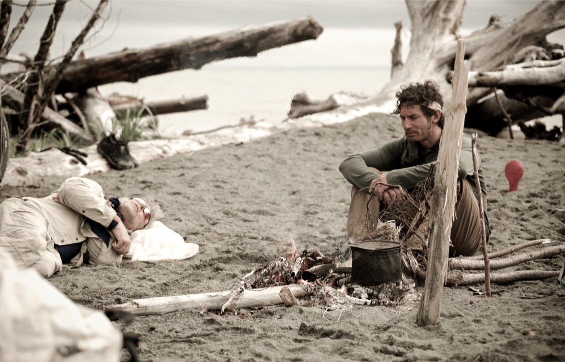 People sitting on a beach by a fire