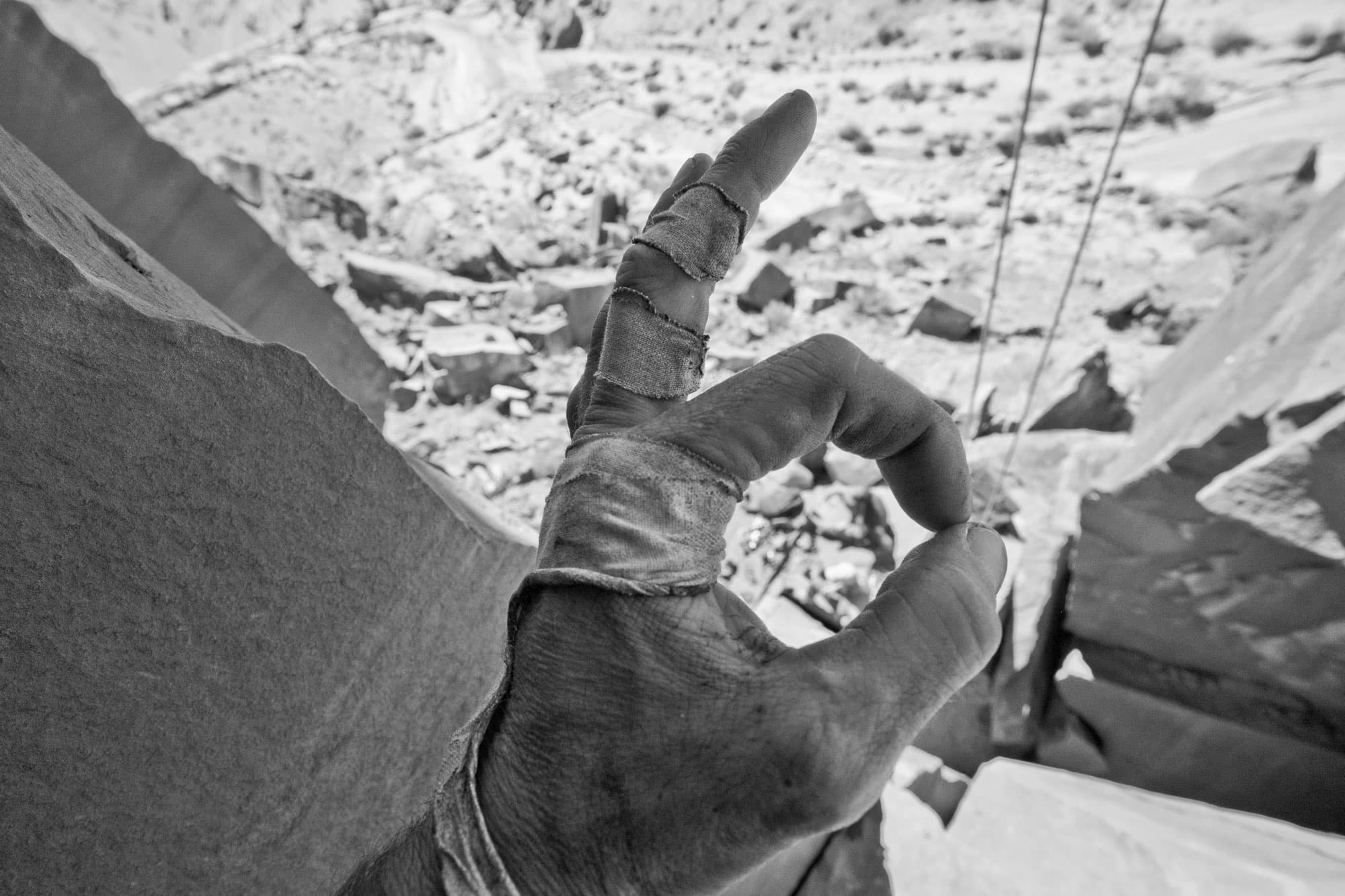 black and white photo of climber making an ok sign with hand