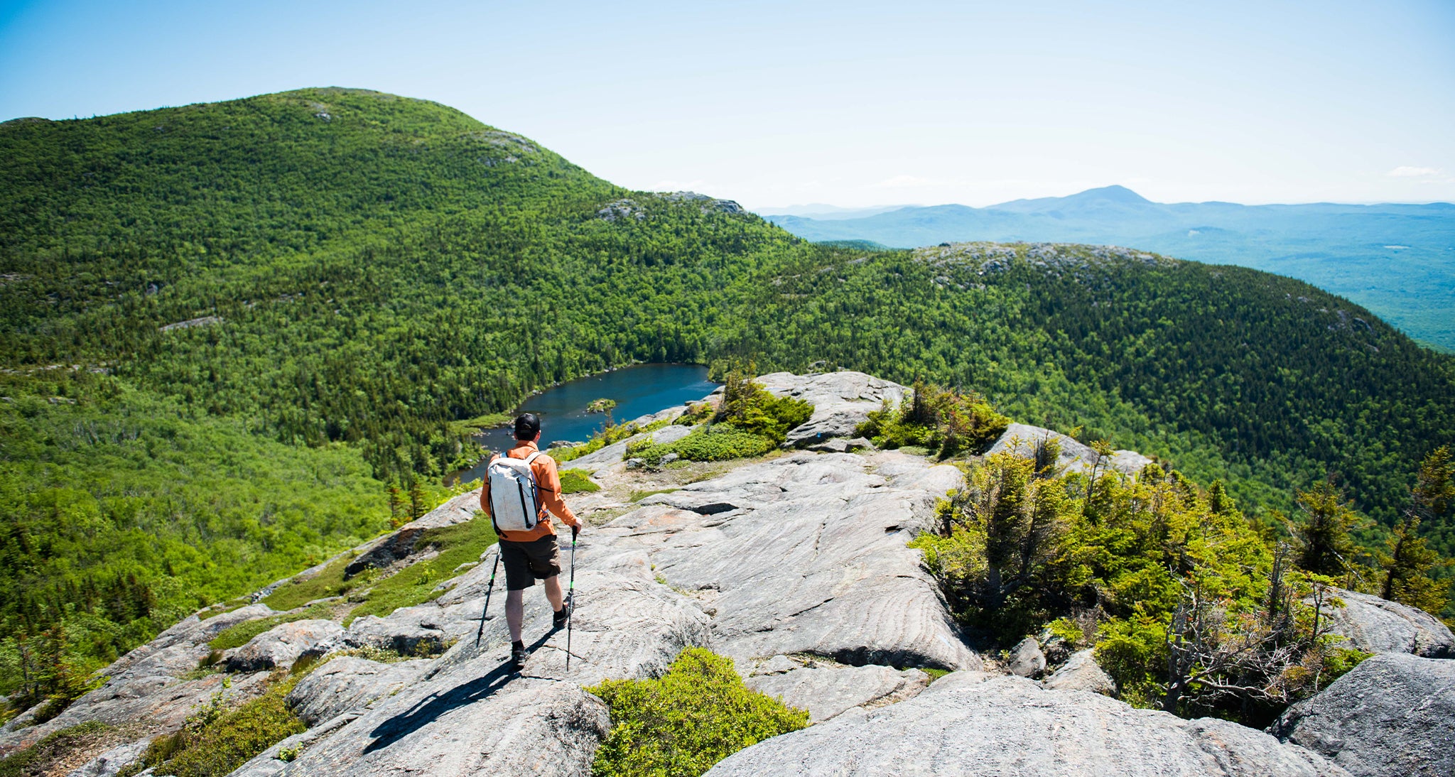 Hiker overlooking the lush green mountains below