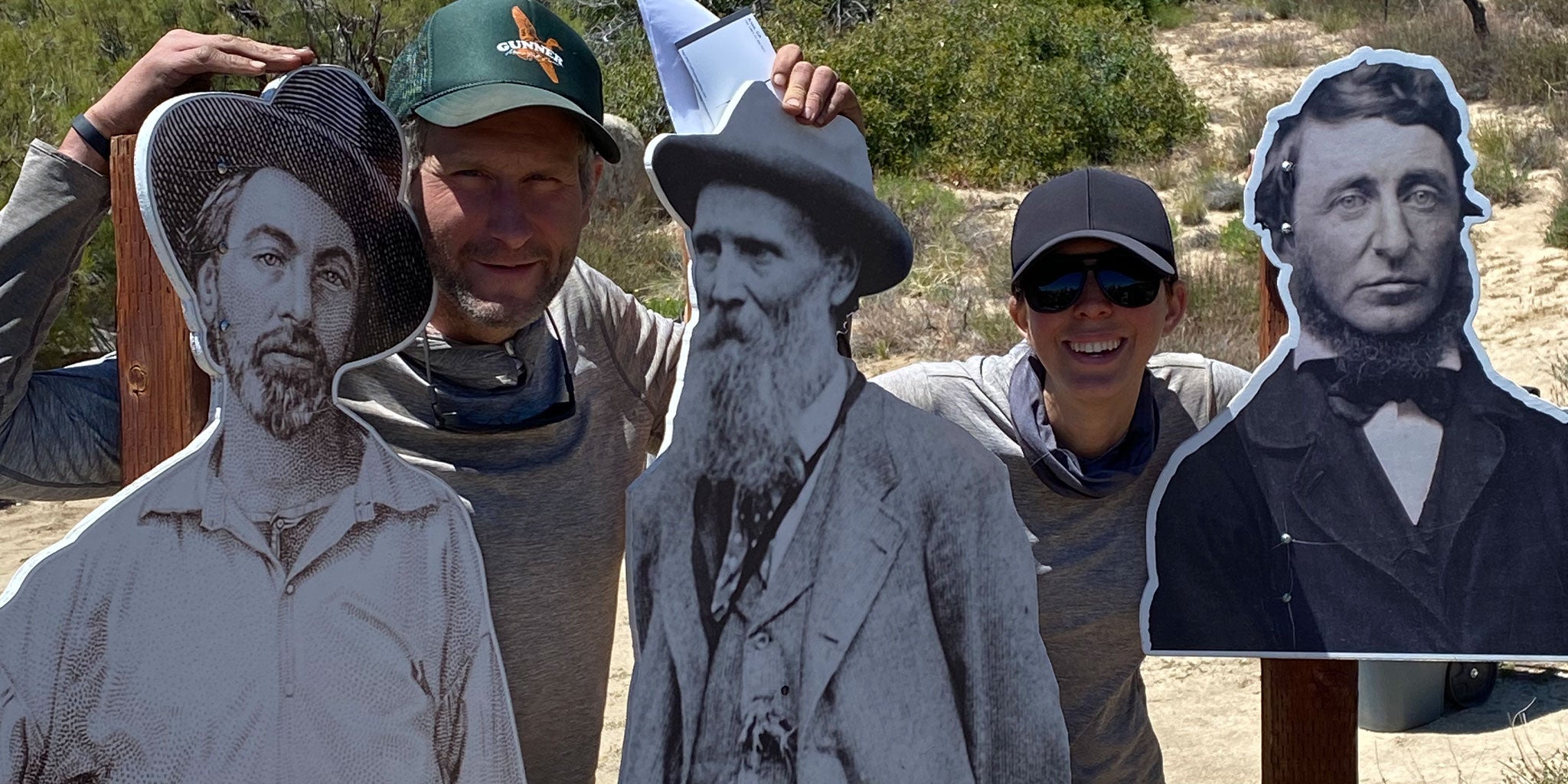 Hikers pose with cardboard cutouts on the trail