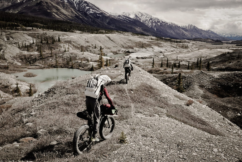 Ultralight Bikepackers riding along gravel