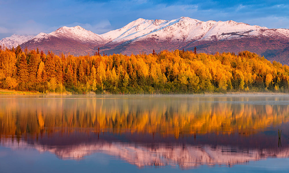 Lakeside fall foliage with snowcapped mountains