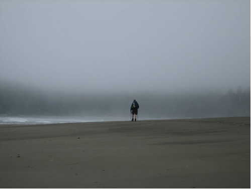 Ultralight hiker on foggy beach