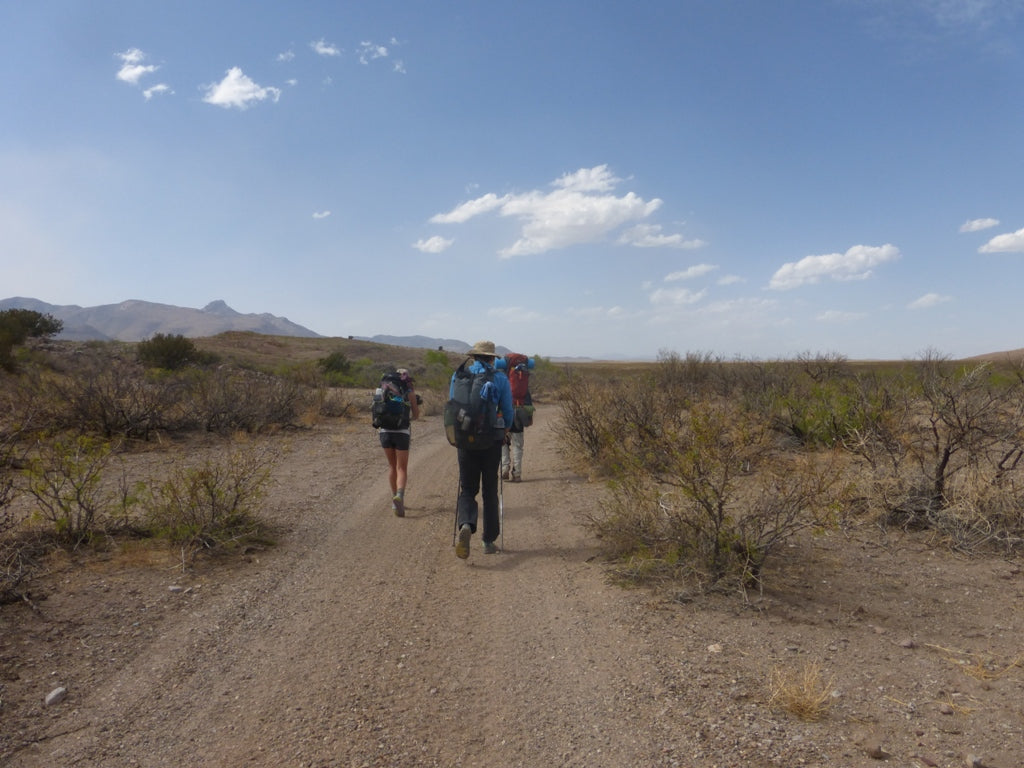 Ultralight backpackers on dirt road