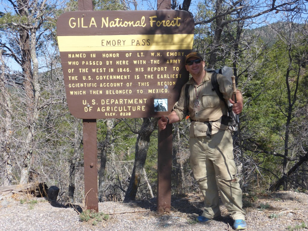 Ultralight hiker posing next to sign for Gila National Forest