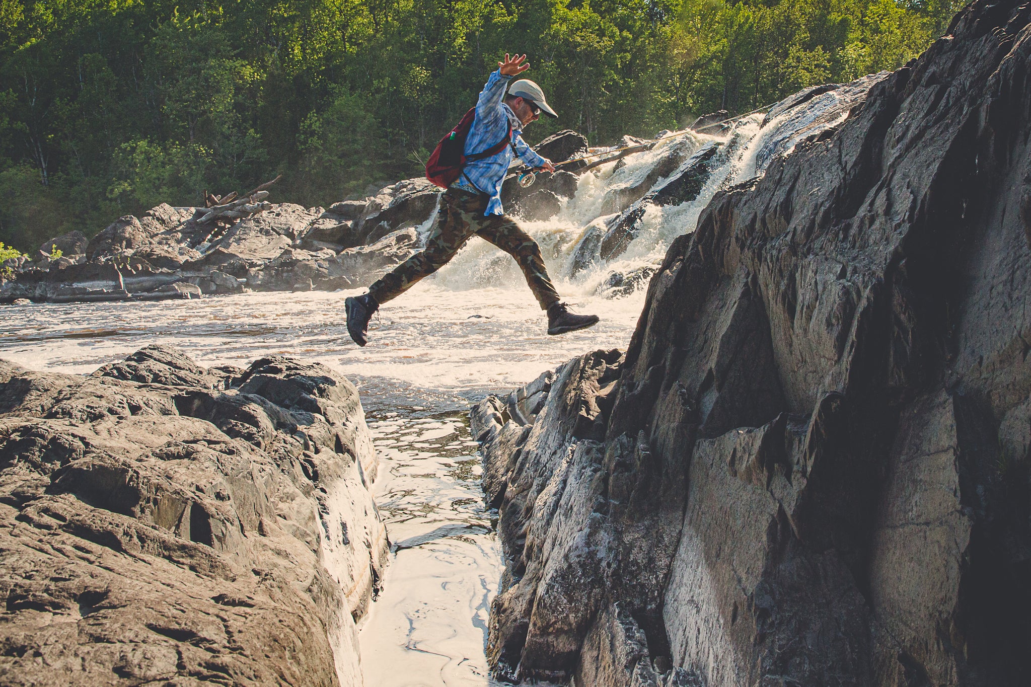 Hiker jumps over a small section of the river