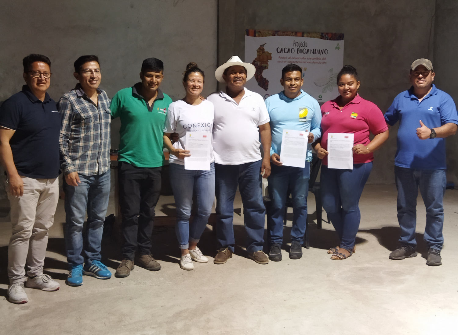Conexion Chocolate team standing together with the young farmers in Ecuador