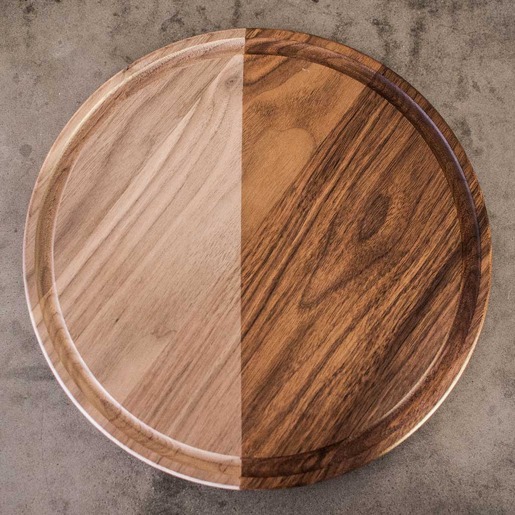 top view of round walnut cutting board, half with oil and half without
