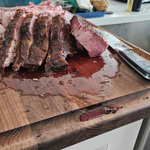best cutting board for brisket shows a cut up brisket with juice oozing out onto cutting boards juice groove