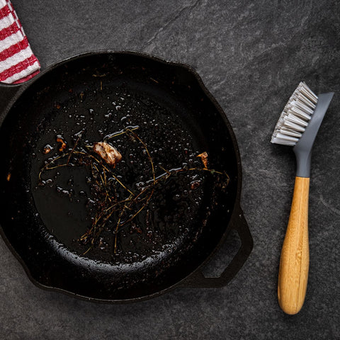 cleaning cast iron cookware with a scrub brush