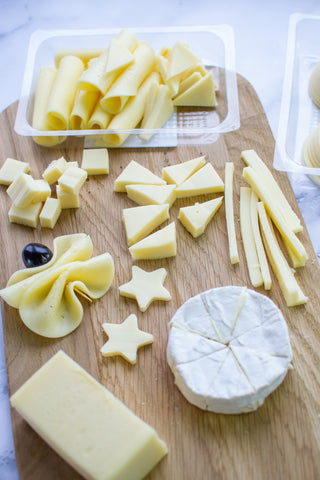 cut up cheese on a wooden board