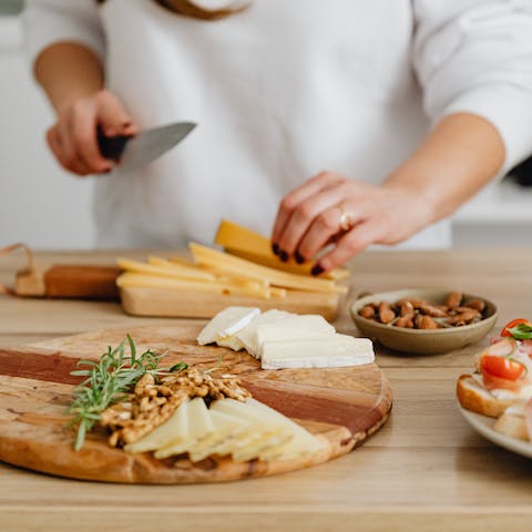 Person Slicing Cheese on Brown Wooden Chopping Board