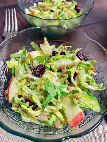 shaved brussel sprout salad in a glass bowl