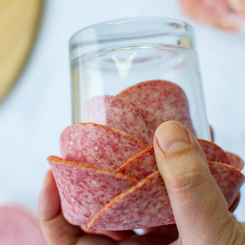 using a small shot glass to make charcuterie meat flower